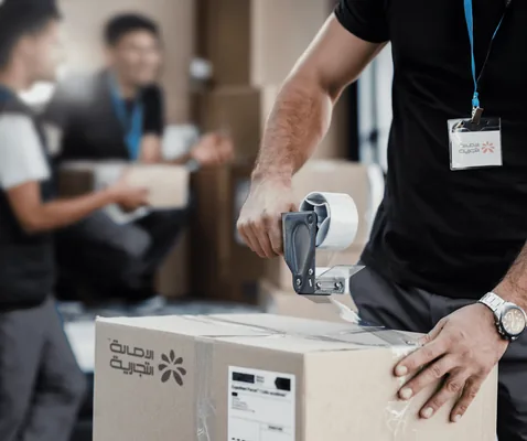 closeup-delivery-man-closing-carboard-box-with-tape-while-preparing-packages-shipment